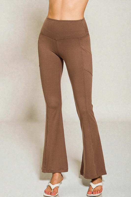 Brown flared pants worn by a person on a plain background