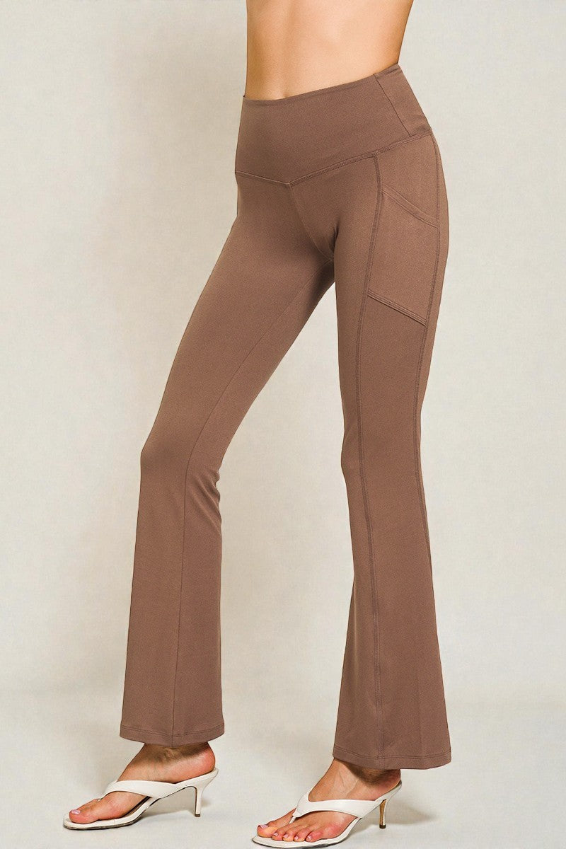 Brown flared pants worn by a person on a plain background