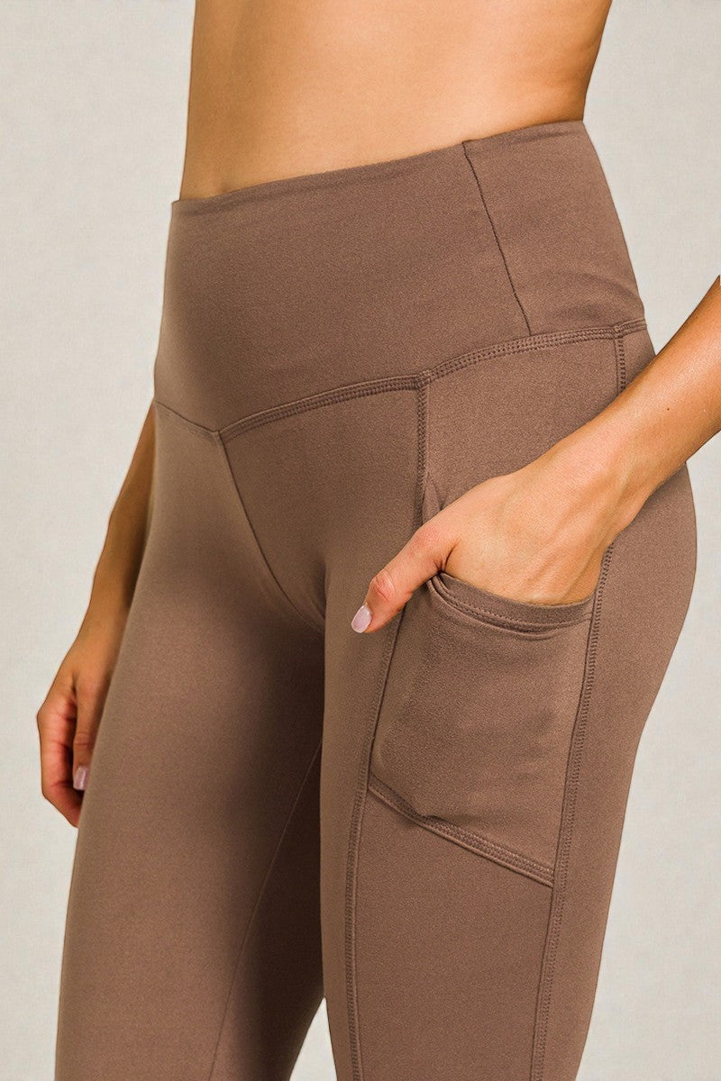 Brown leggings with pockets on a neutral background
