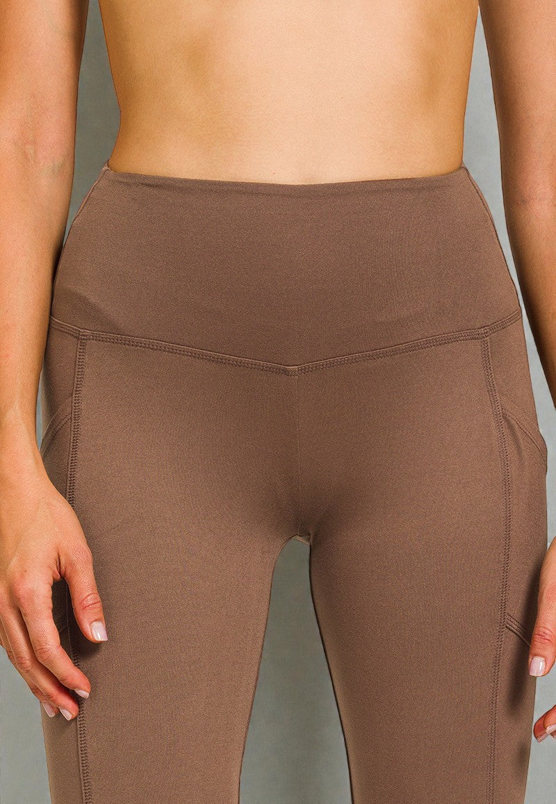 Brown leggings worn by a person on a gray background