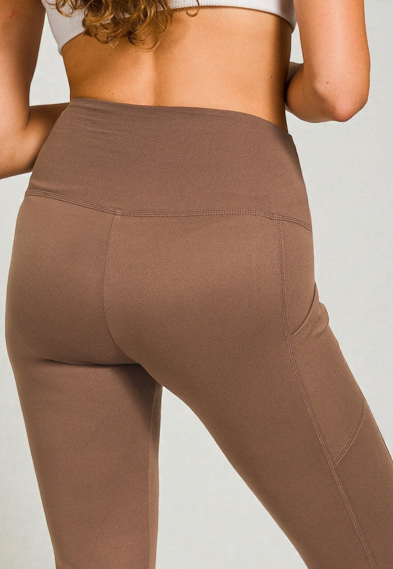 Brown leggings worn by a person on a plain background
