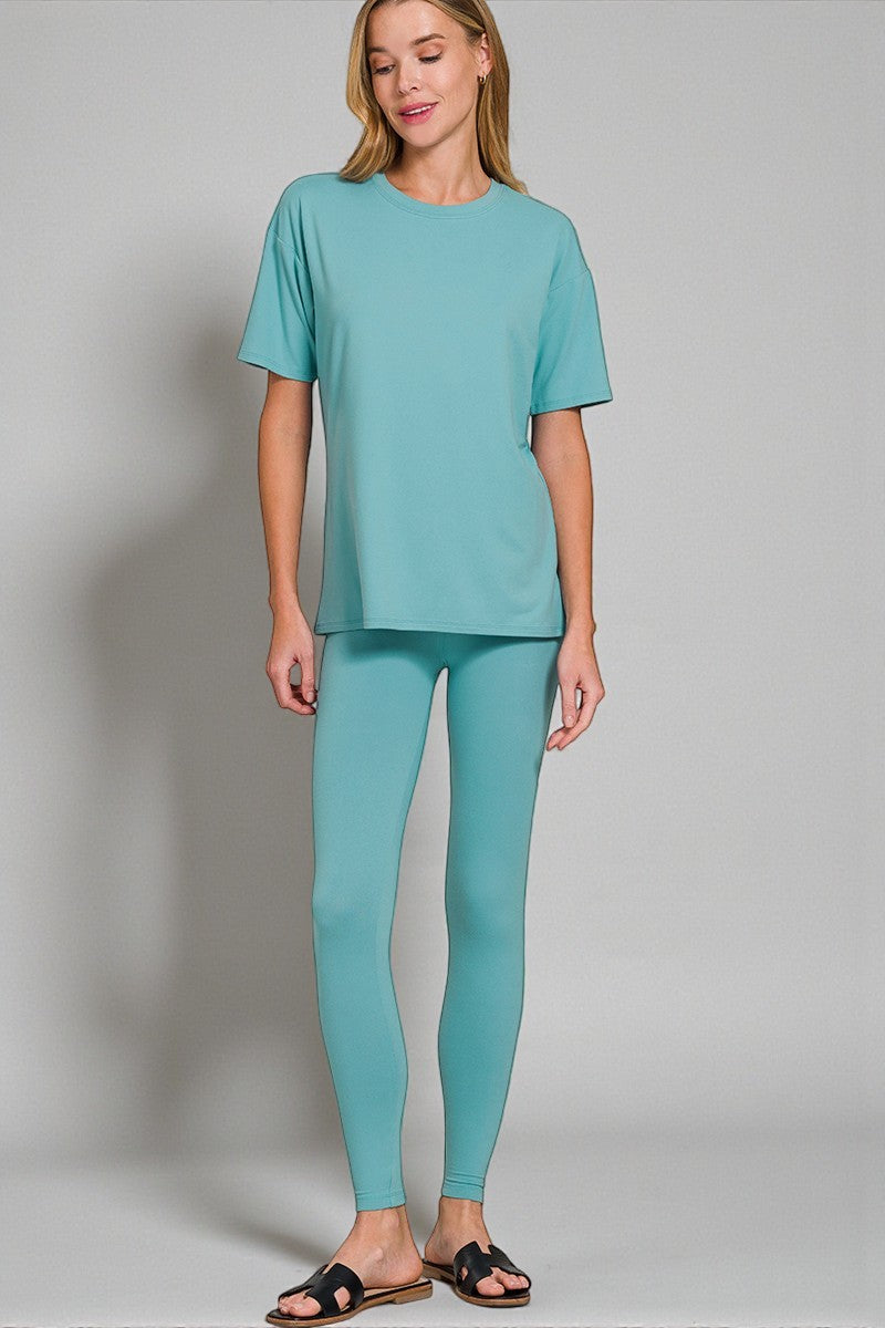 Woman wearing a teal outfit on a plain background