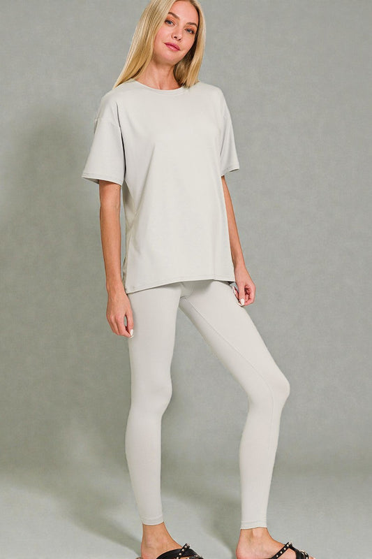 Woman wearing a light gray outfit on a plain background