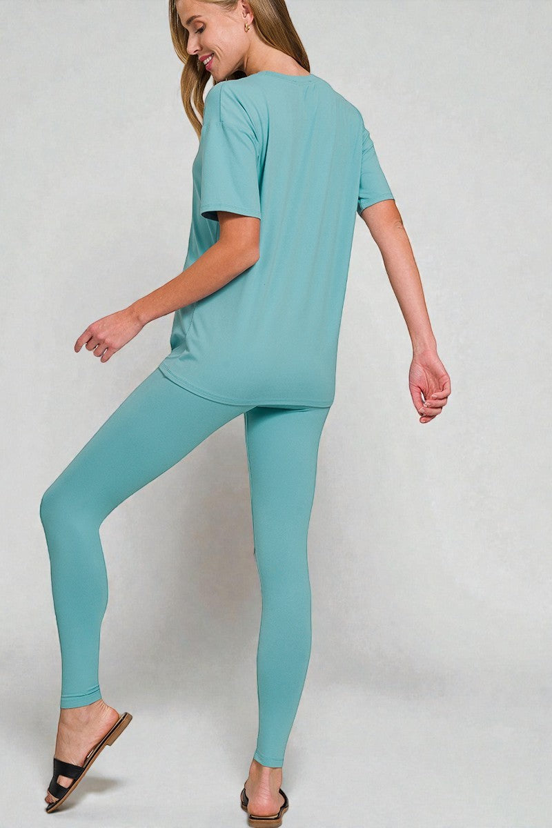 Woman wearing a teal outfit on a plain background