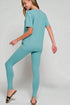 Woman wearing a teal outfit on a plain background