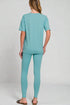 Person wearing a teal outfit on a plain background