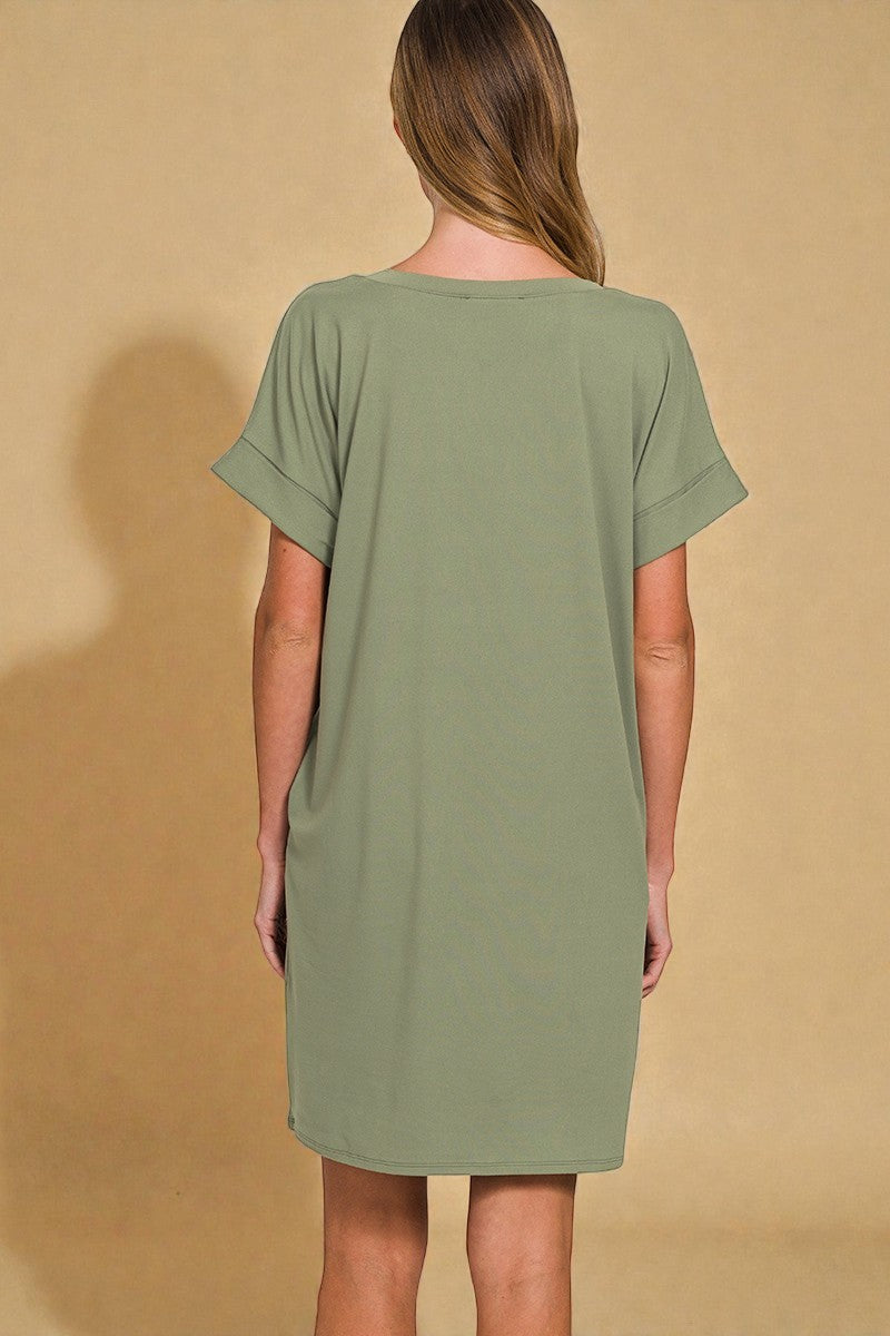 Woman wearing a green dress against a beige background