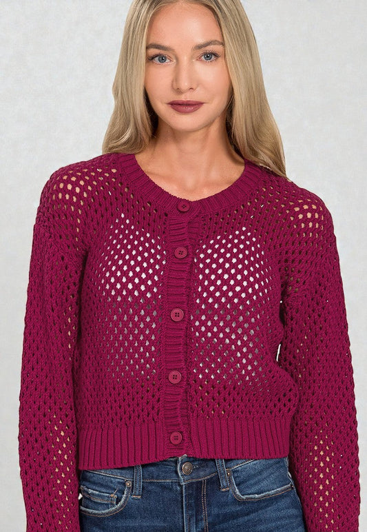 Woman wearing a purple open-knit cardigan against a plain background