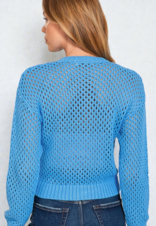 Woman wearing a blue open-knit sweater against a white background