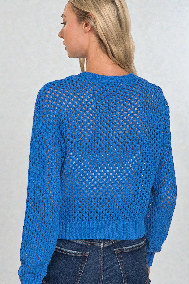 Blue open-knit sweater worn by a person on a plain background