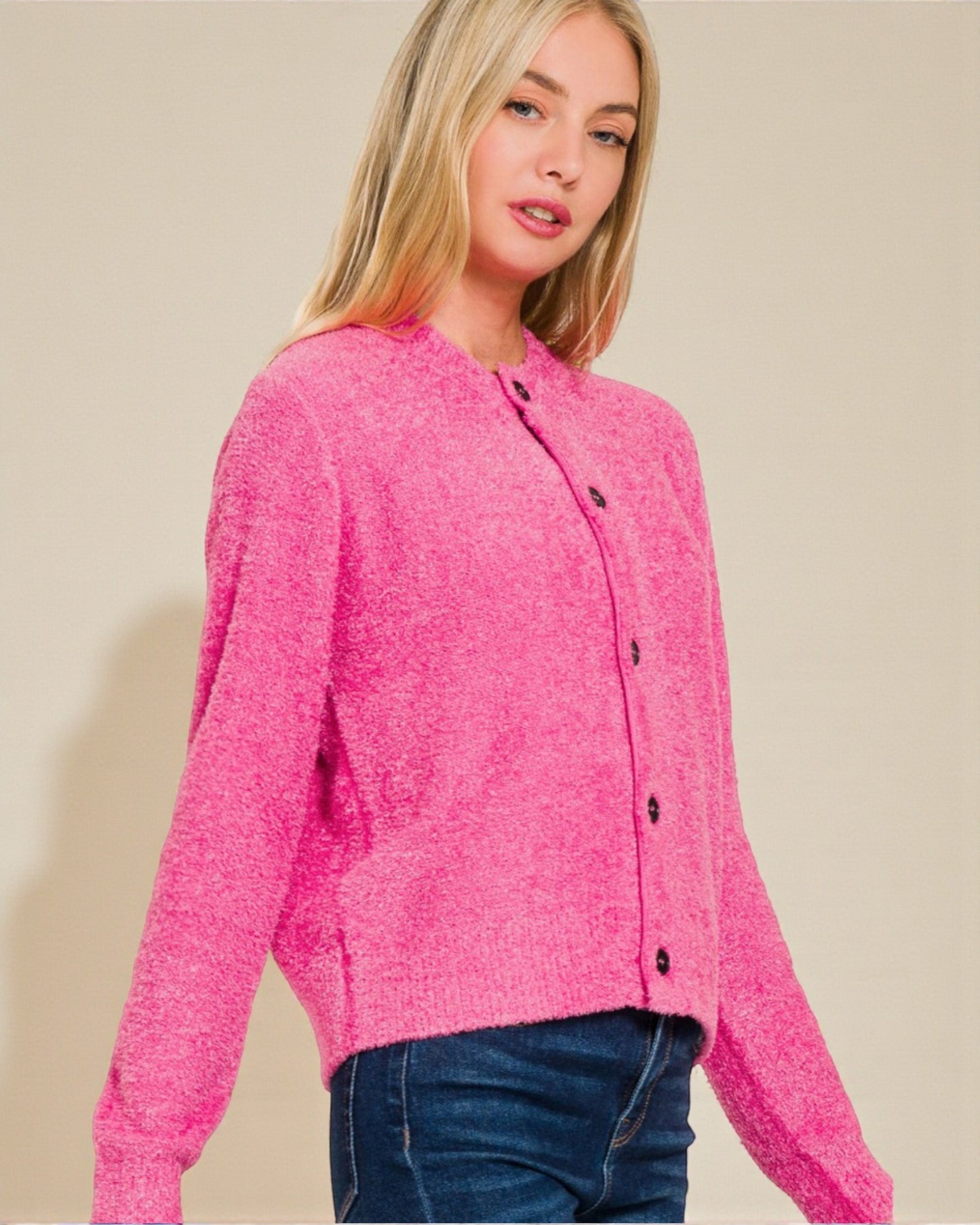 Woman wearing a pink cardigan against a beige background