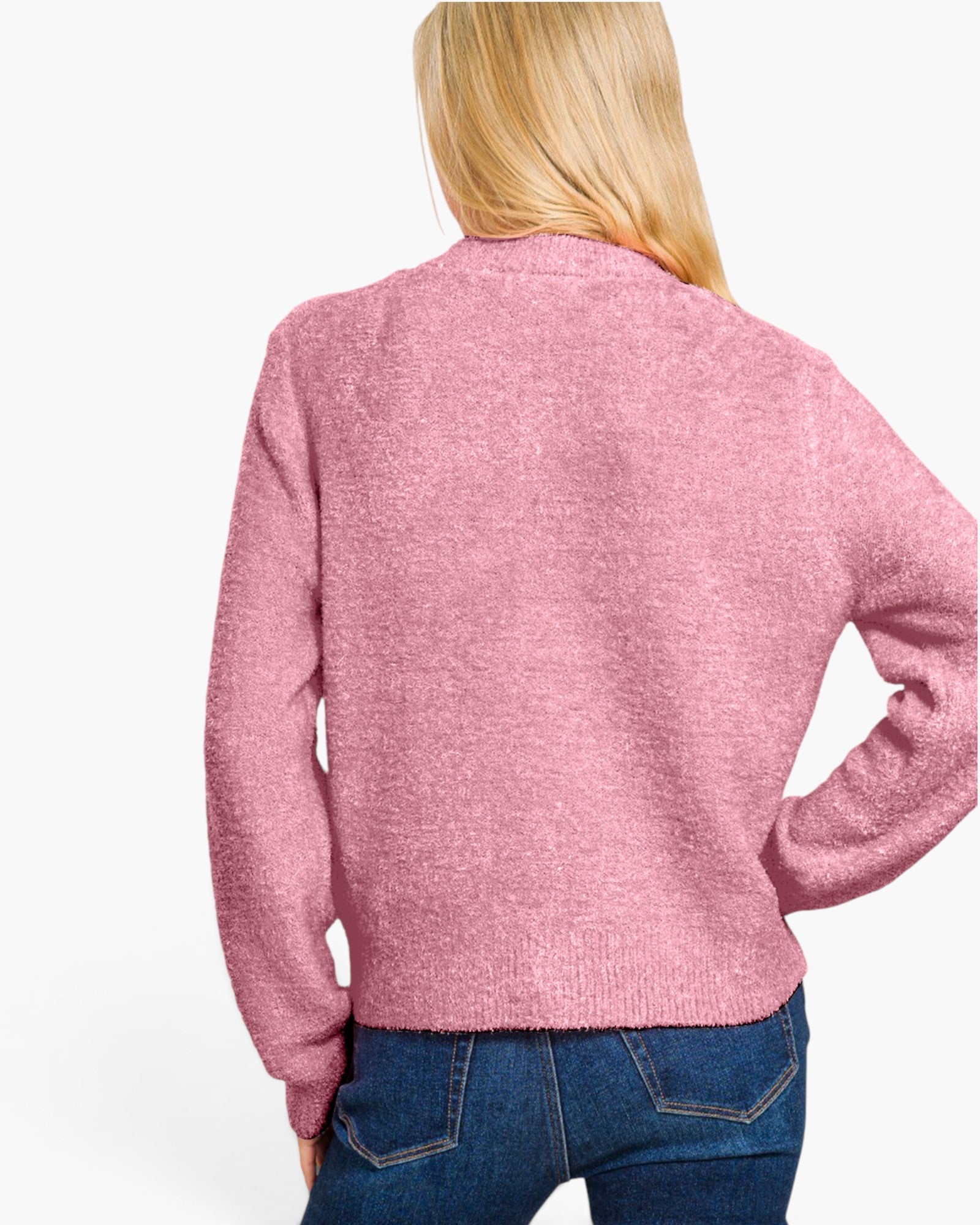 A woman viewed from the back wearing a heathered pink knit sweater and blue jeans against a plain white studio background.