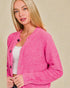 Woman wearing a pink cardigan against a beige background