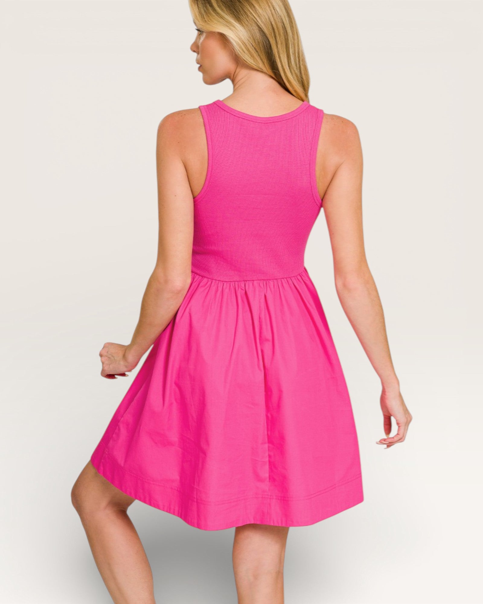 Woman wearing a pink dress on a plain background