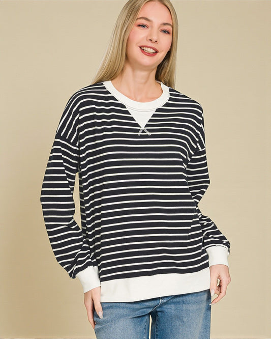 Woman wearing a black and white striped sweater with a beige background