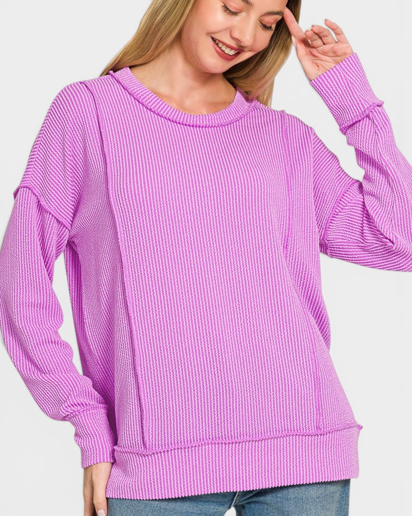 Woman wearing a purple sweater on a light gray background