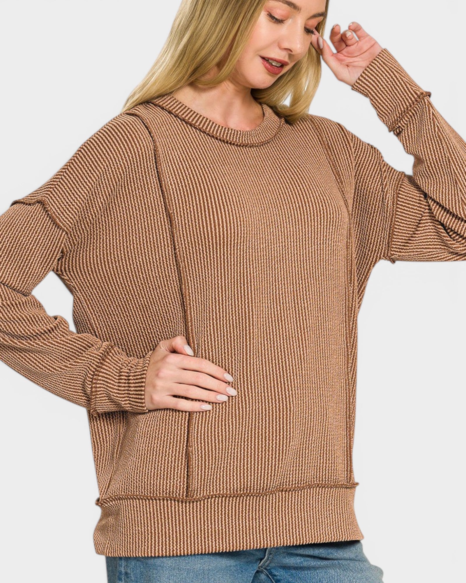 Woman wearing a brown ribbed sweater on a white background