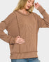 Woman wearing a brown ribbed sweater on a white background