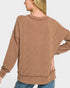 Woman wearing a brown ribbed sweater on a white background