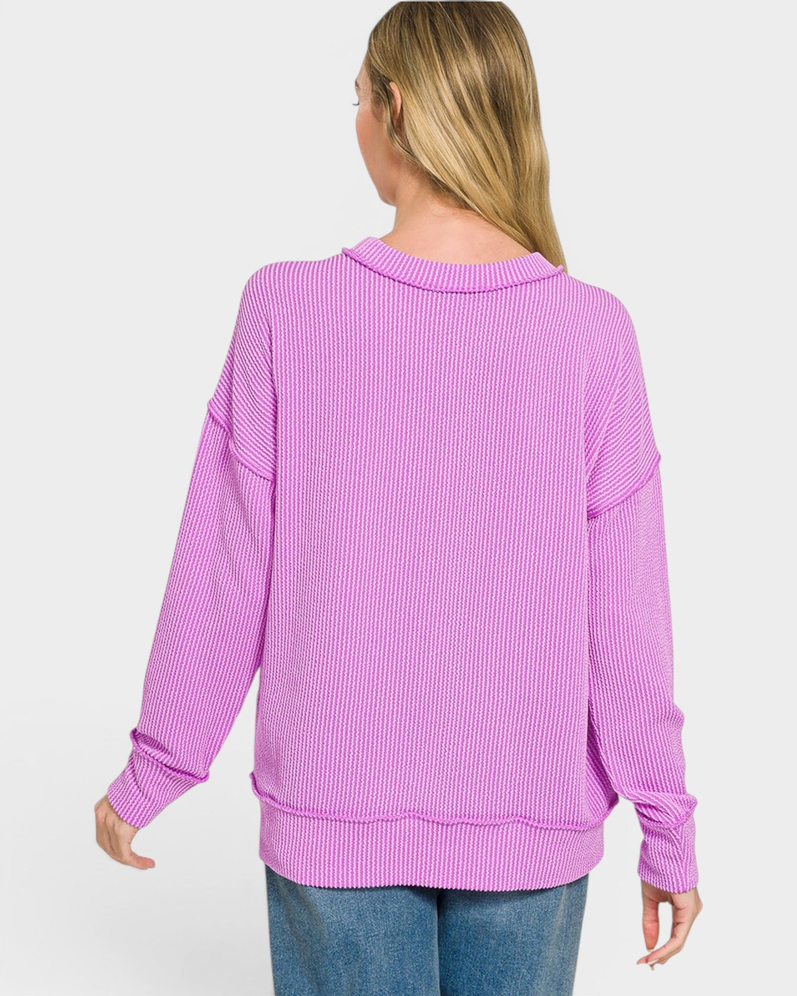 Woman wearing a purple ribbed sweater on a white background