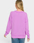 Woman wearing a purple ribbed sweater on a white background