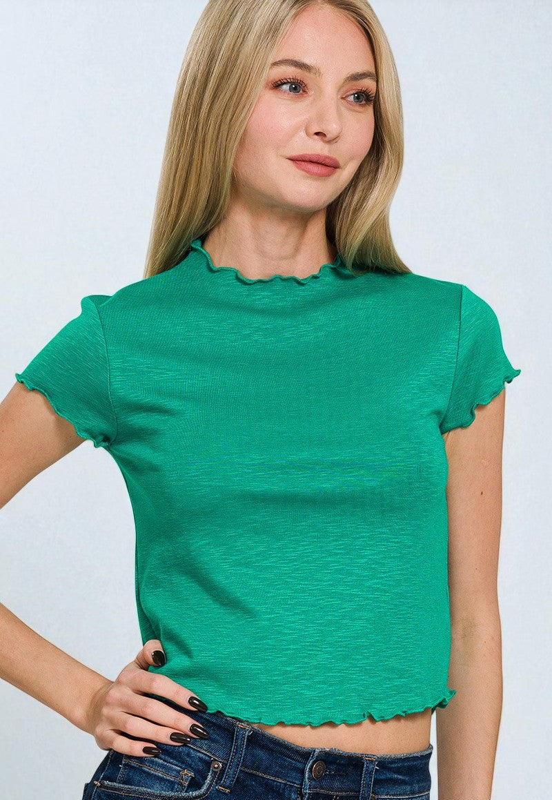Woman wearing a green top with ruffled sleeves on a white background