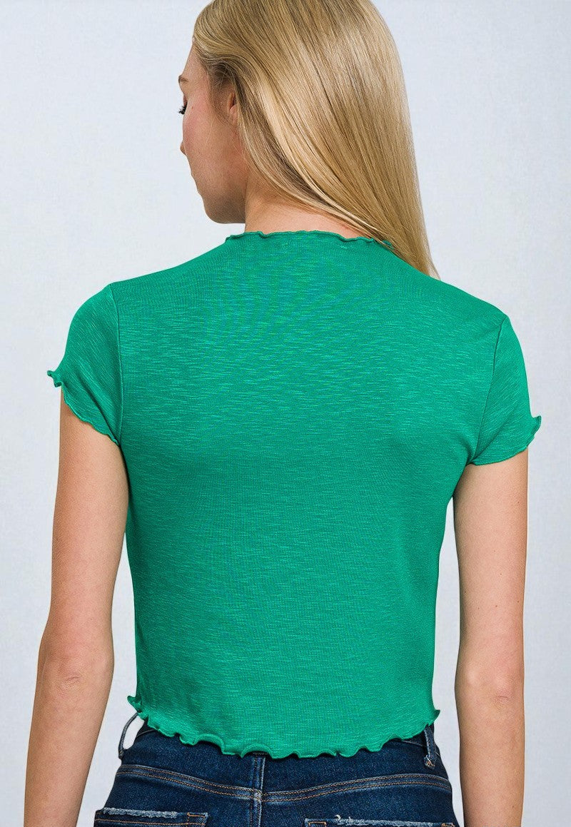Person wearing a green t-shirt and blue jeans on a plain background