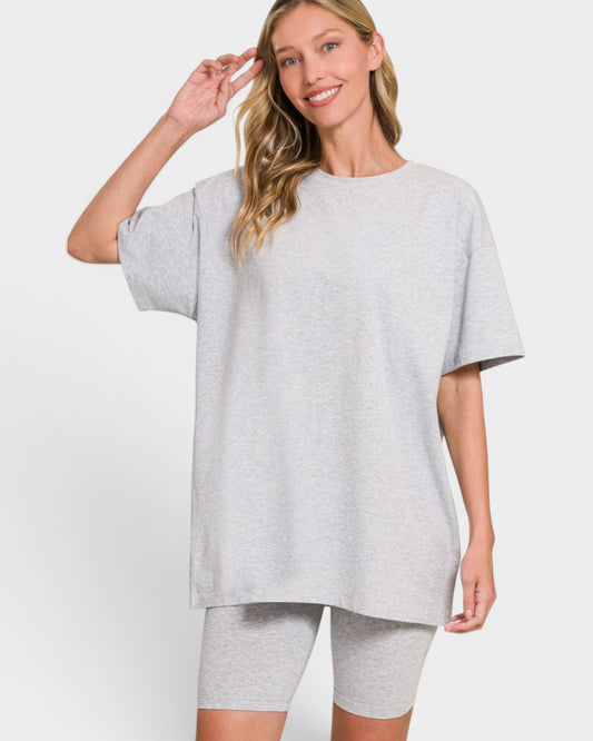 Woman wearing a gray oversized t-shirt and shorts on a white background
