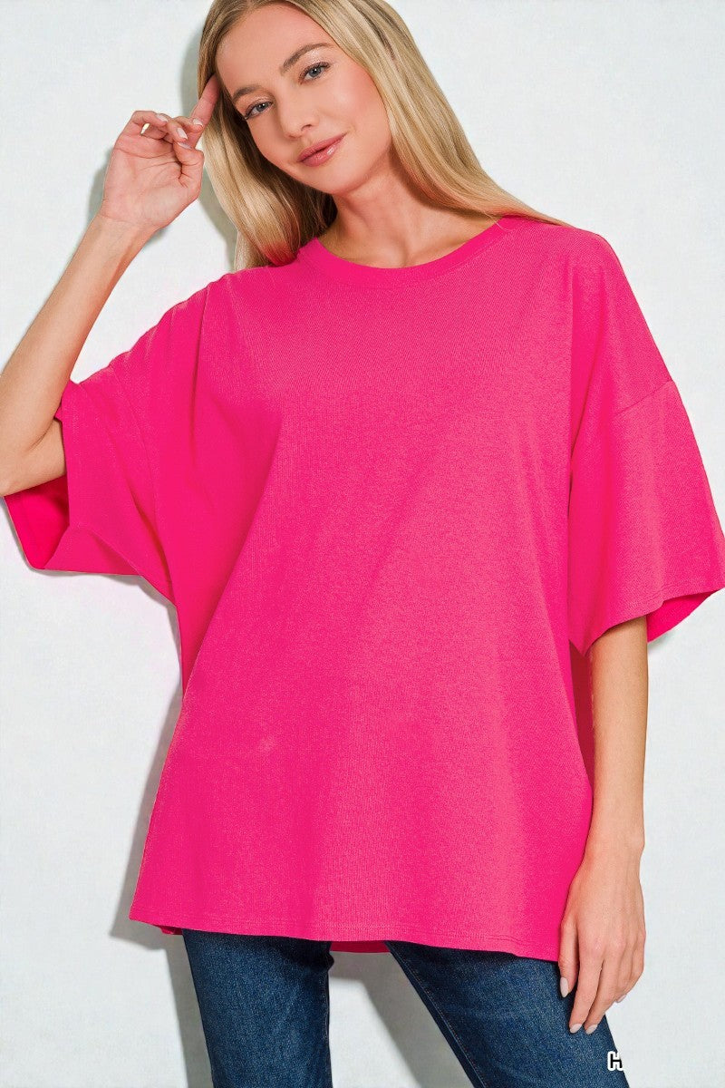 Woman wearing a bright pink oversized t-shirt against a white background