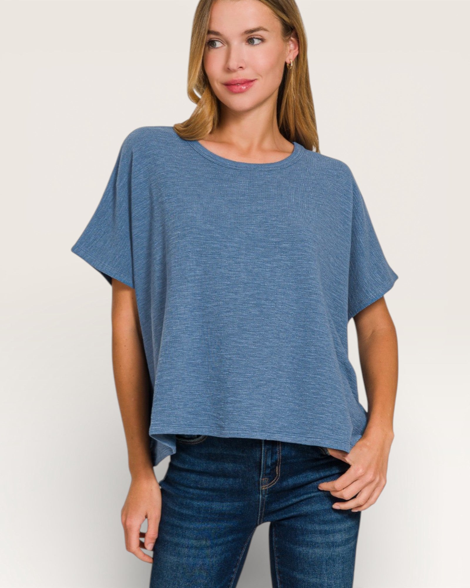Woman wearing a blue oversized t-shirt and jeans on a white background