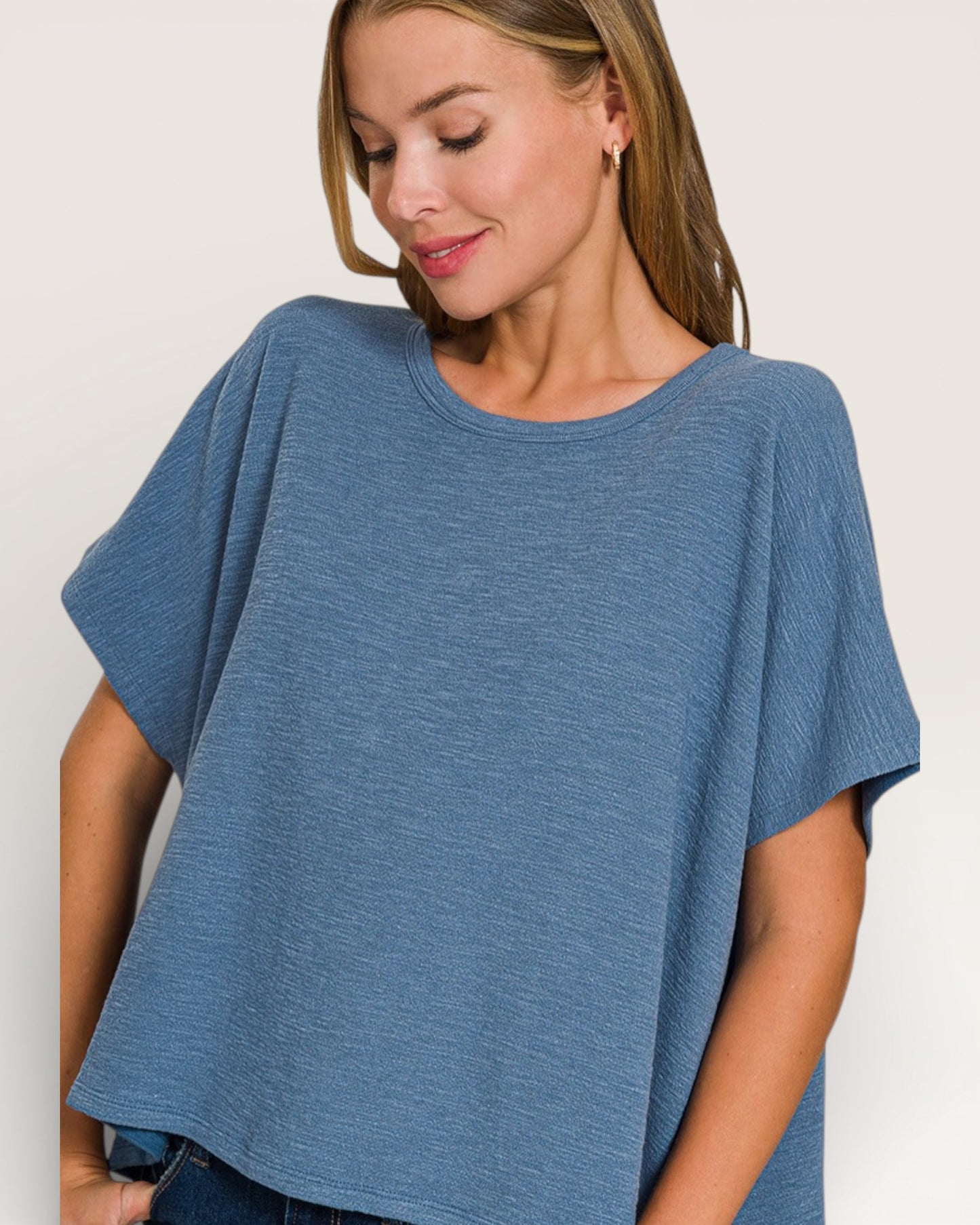 Woman wearing a blue oversized t-shirt against a plain background