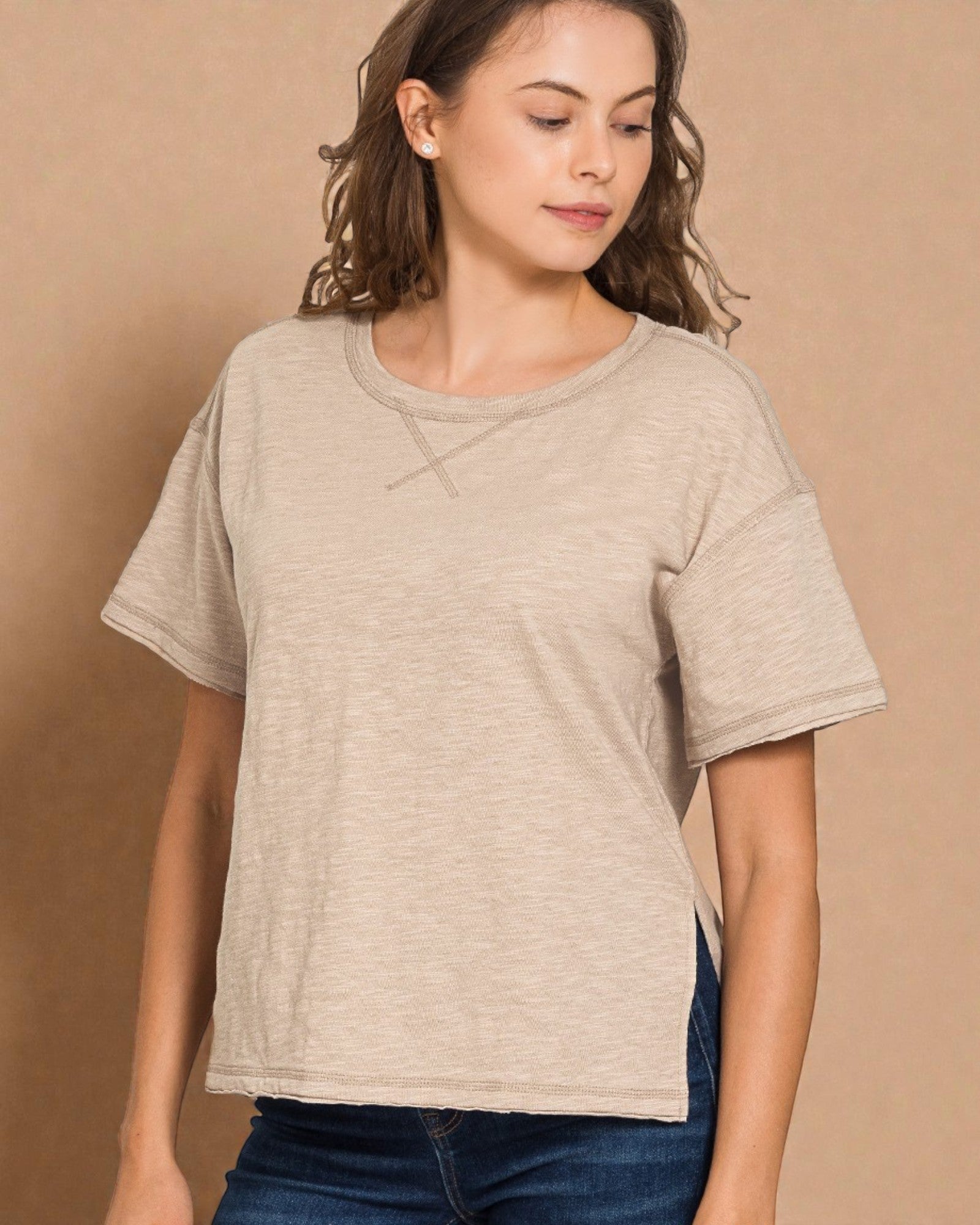 Woman wearing a beige t-shirt against a brown background