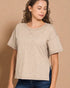 Woman wearing a beige t-shirt against a brown background