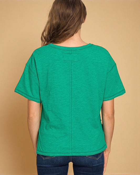 Green t-shirt worn by a person on a beige background