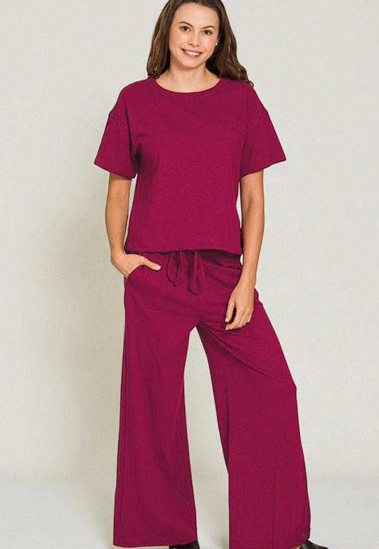 Woman wearing a matching maroon top and wide-leg pants against a plain background