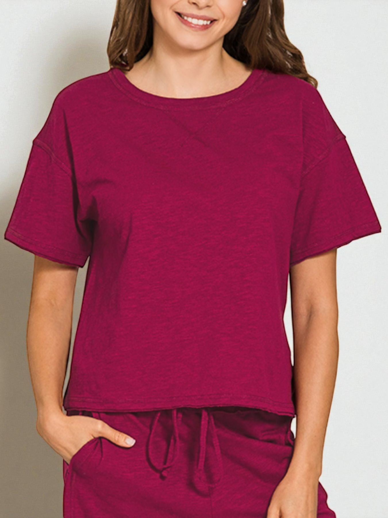 Person wearing a maroon t-shirt and pants on a plain background