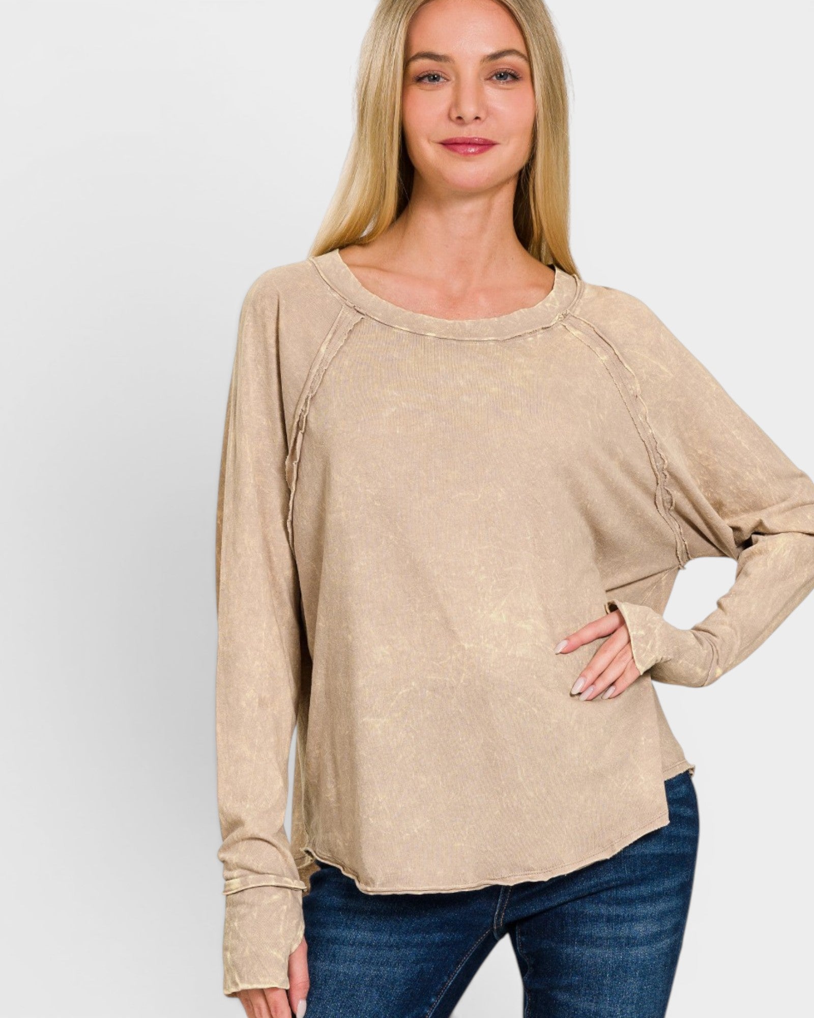 Woman wearing a beige long-sleeve top against a white background