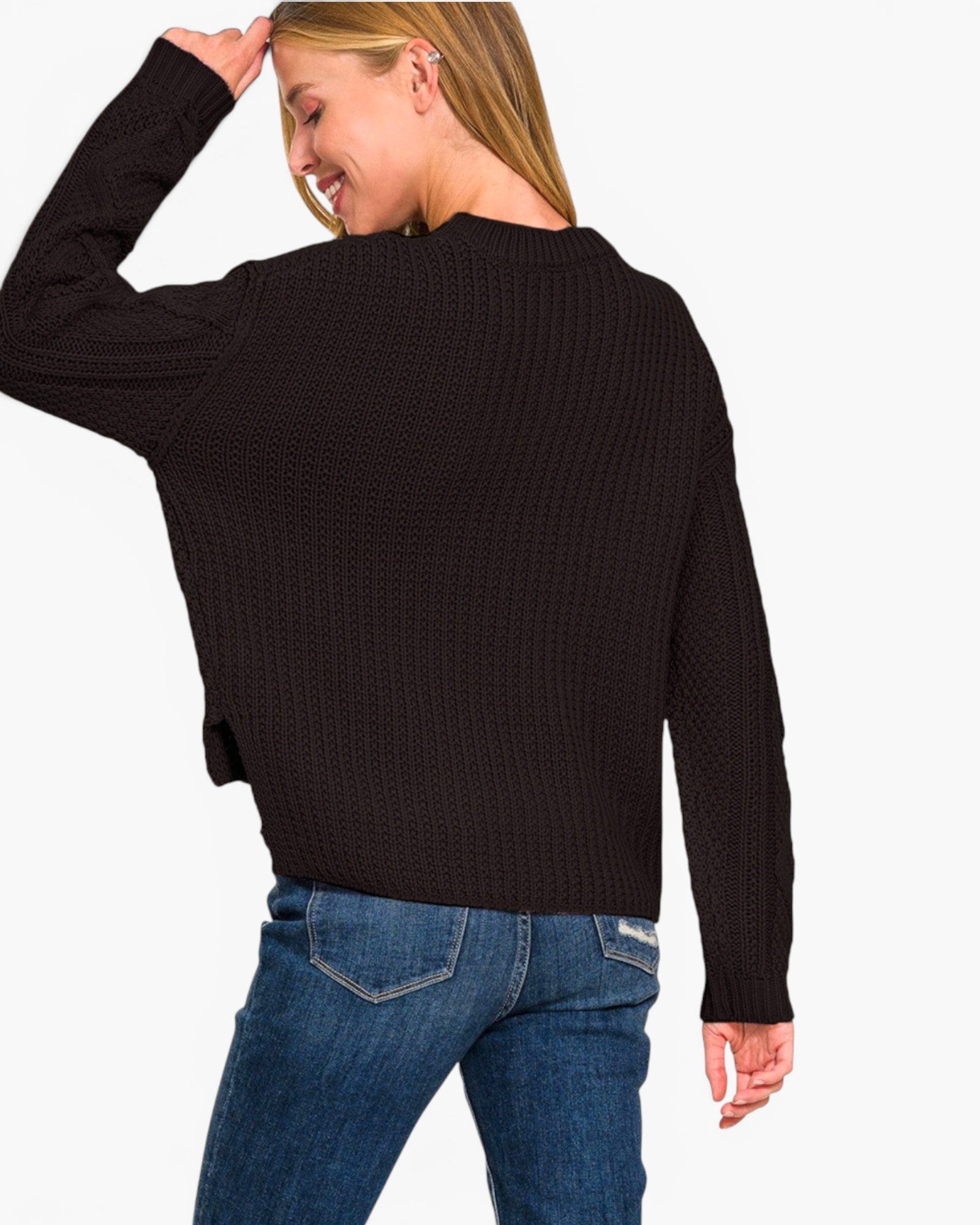 A woman wearing a black ribbed knit sweater and blue jeans, shown from the back against a plain white background.