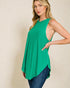 Woman wearing a green sleeveless top with a beige background