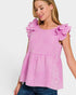Woman wearing a pink checkered top with ruffled sleeves on a white background