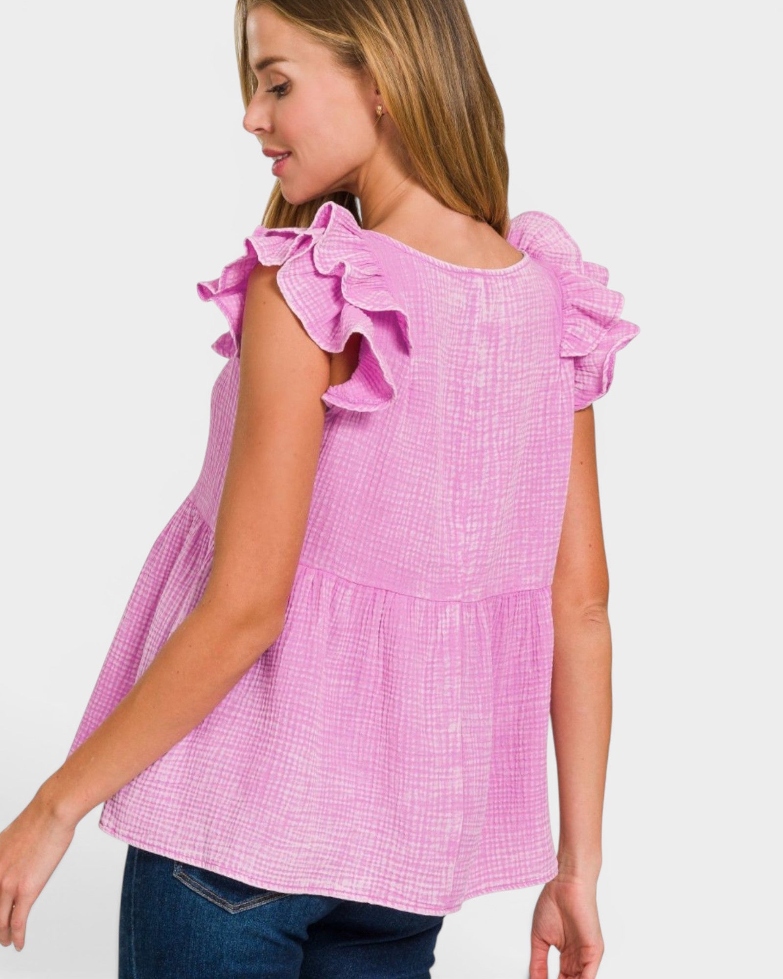 Woman wearing a pink ruffled blouse against a white background