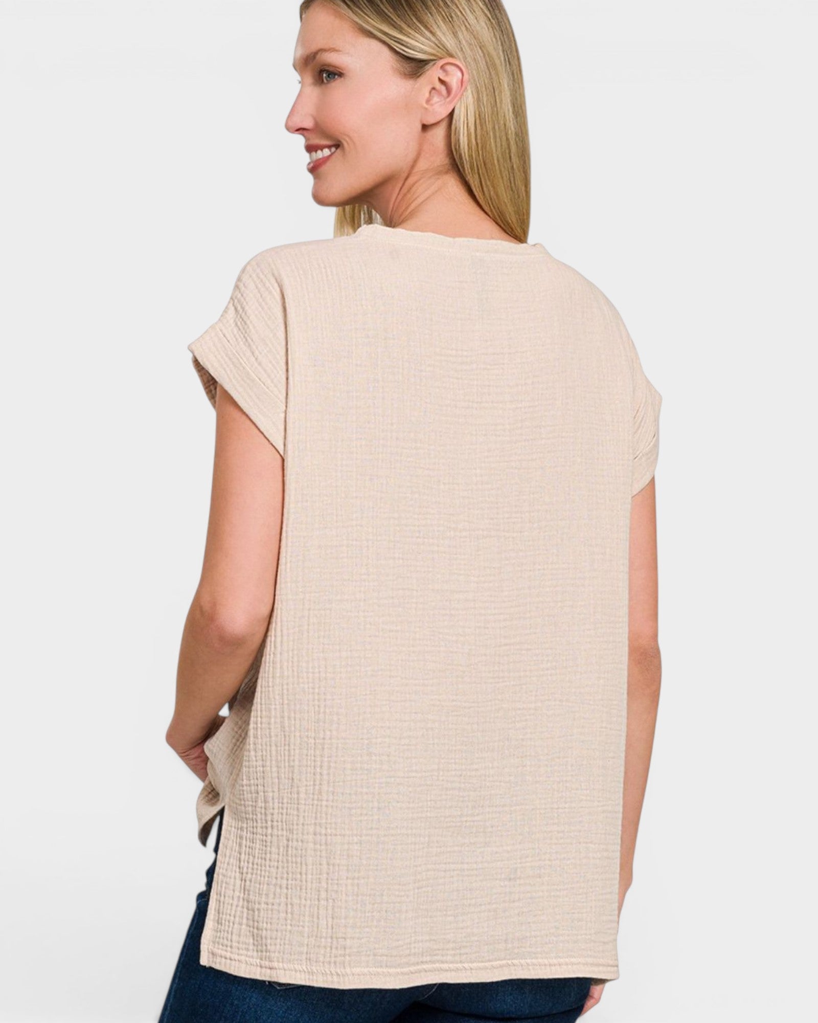 Woman wearing a beige sleeveless top on a white background