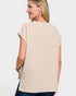Woman wearing a beige sleeveless top on a white background