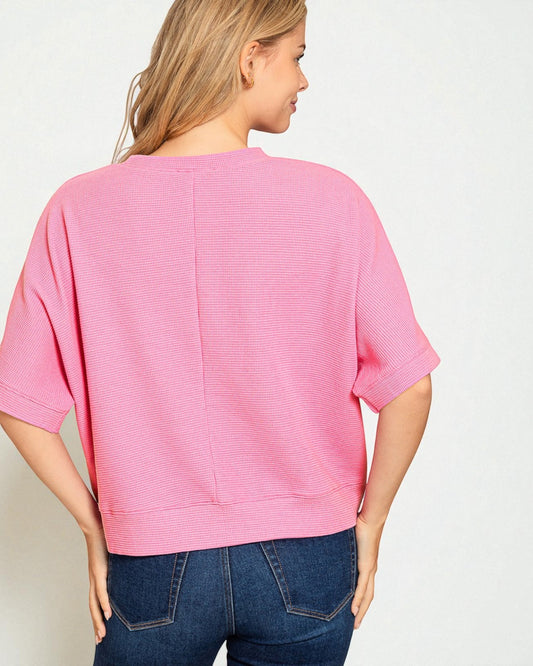 Woman wearing a pink sweater and blue jeans on a white background