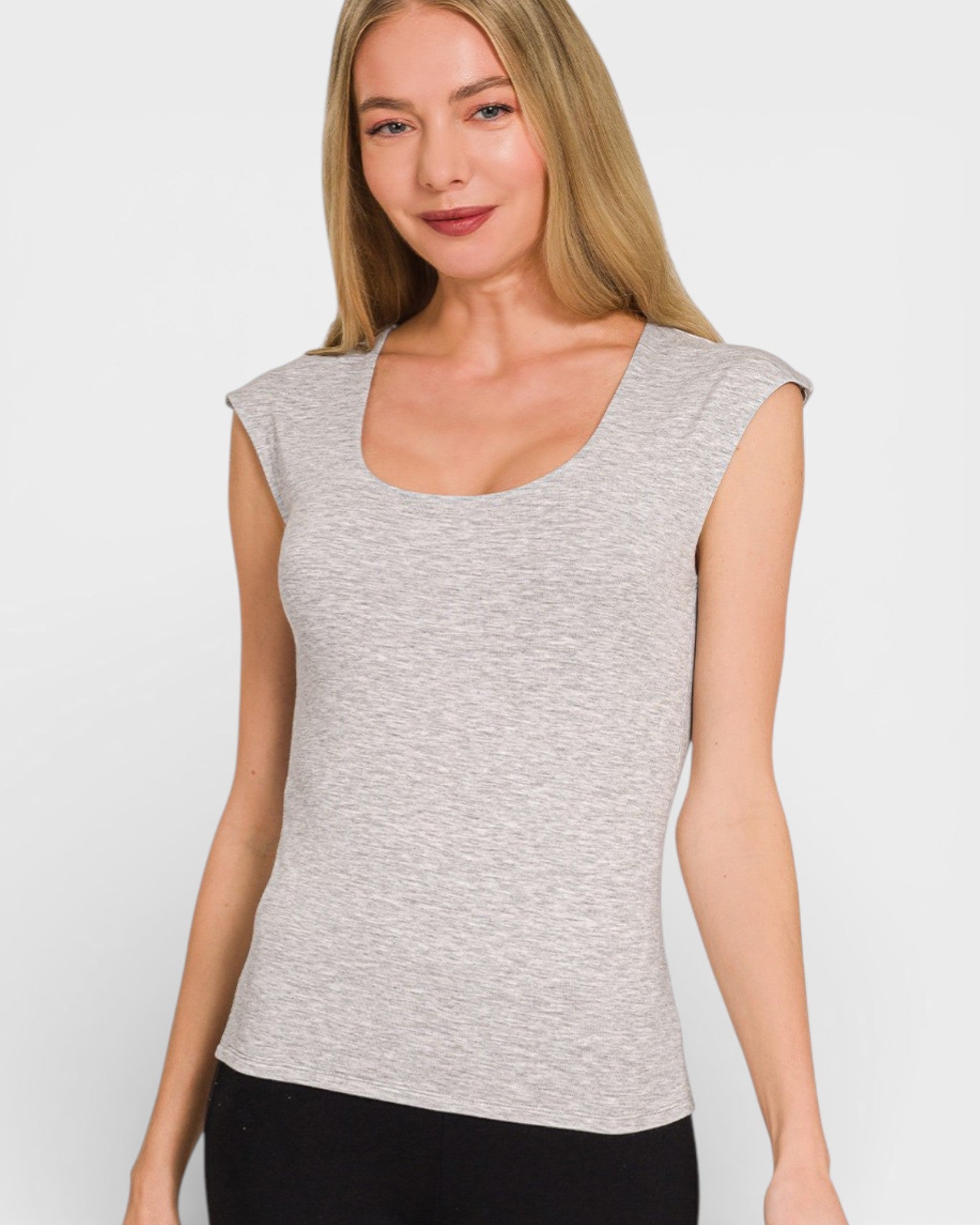 Woman wearing a gray sleeveless top against a white background
