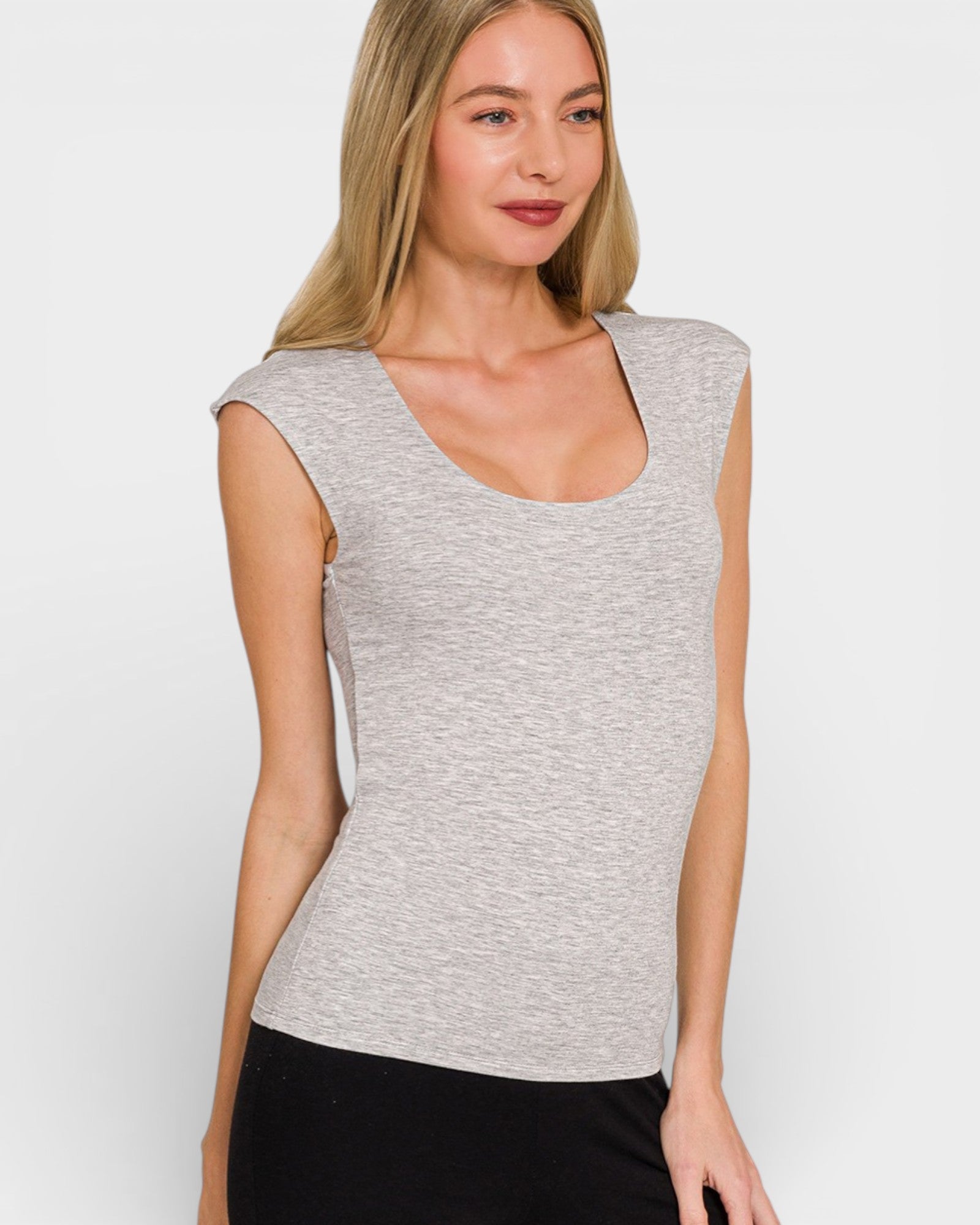 Woman wearing a gray sleeveless top against a white background