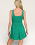 Green dress worn by a person on a plain background