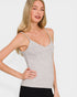 Woman wearing a gray tank top against a plain background