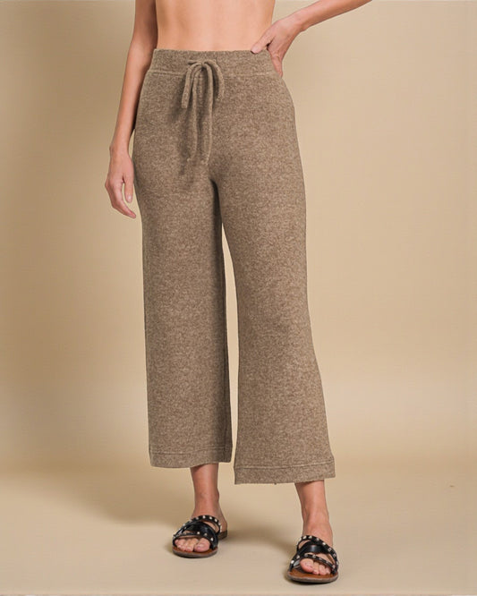 Person wearing brown wide-leg pants on a beige background