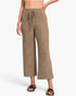 A model wearing a pair of wide-leg cropped pants in a heathered taupe-brown color, paired with black slide sandals, against a clean white studio background.